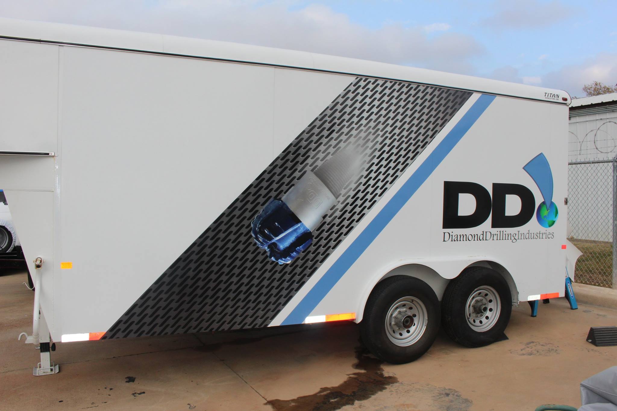 DDI Trailer Wrap Driver Side - Professional vehicle graphics with service icons and brand colors